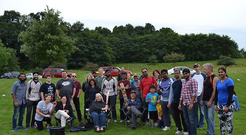 Group photo of staff with cricket equipment