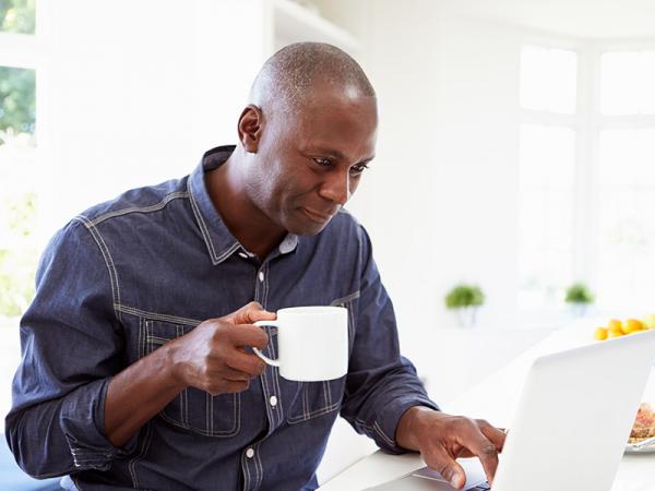 Man at computer with cup of coffee
