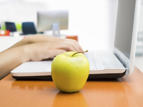 hands on laptop with apple