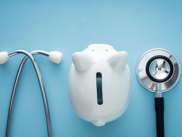 Piggy bank surrounded by a stethoscope