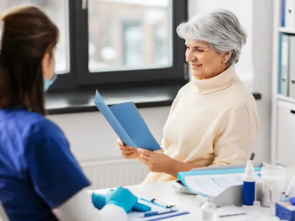 Women looking at pamphlet sitting with nurse.