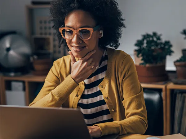 Woman sitting at desk watching a video.