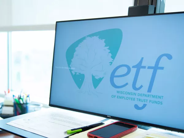 ETF computer and desk with papers scattered about