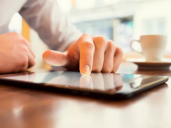 Finger on tablet reading news