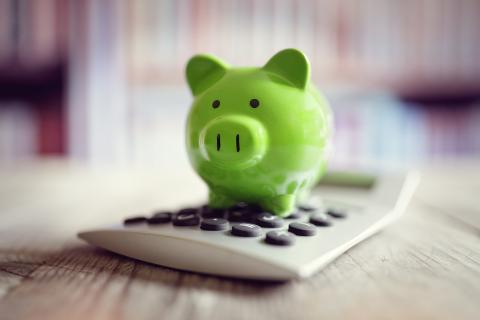 green piggy bank on a small calculator