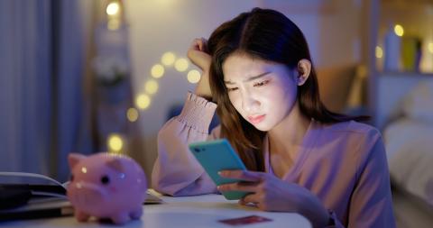 young woman examining finances on mobile device
