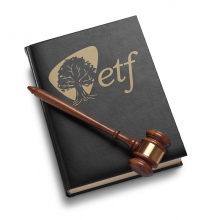 A gavel resting on a black book with the ETF logo in gold lettering on it.