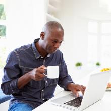 Man at computer with cup of coffee
