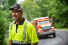 highway worker in front of truck