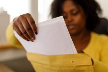 Young woman retrieving documents in a yellow envelope.