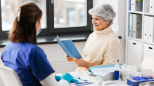 Women looking at pamphlet sitting with nurse.