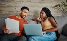 young and woman reviewing finances on laptop