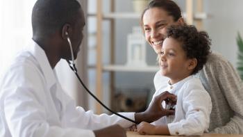 Doctor listening to heartbeat of child with mother